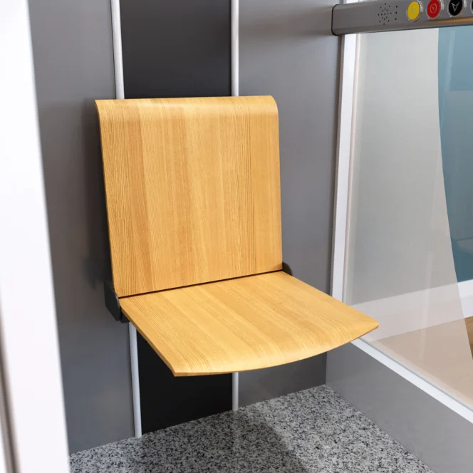 Aan een muur naast een glazen paneel in een lift met een grijs gespikkelde vloer is een opvouwbare houten stoel bevestigd.