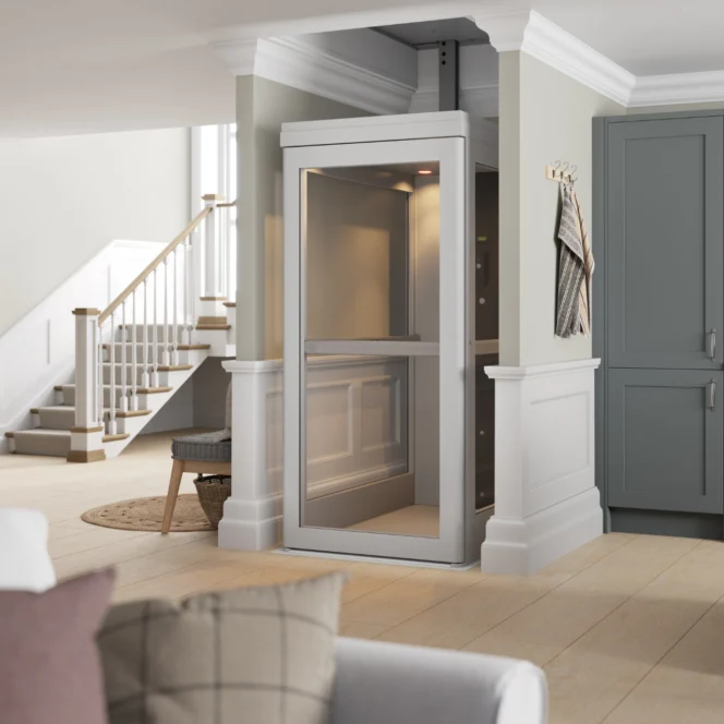 Een moderne huislift, geïnstalleerd in een woonkamer, omringd door lichtgekleurde muren en een eigentijdse inrichting.
