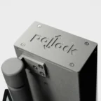 Close-up of a gray metal device featuring the engraved word "Pollock" on its surface, with a cylindrical component attached to the side.