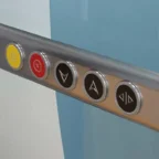 Close-up of five elevator control buttons, including emergency and floor selection buttons, set in a metallic panel.