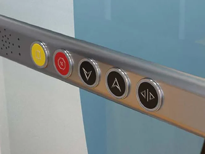 Close-up of five elevator control buttons, including emergency and floor selection buttons, set in a metallic panel.