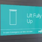 Digital display panel showing a message: "Lift Fully Up" with an emergency contact number at the bottom.