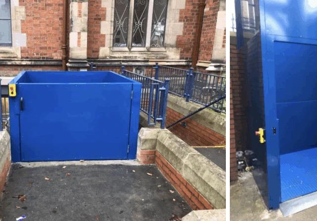 A blue wheelchair lift is installed outdoors next to a sloped walkway and brick building, with safety buttons visible on both exterior and interior panels.